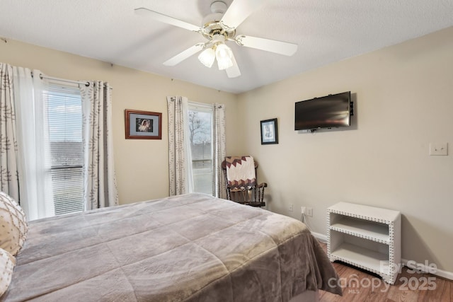 bedroom with wood-type flooring, a textured ceiling, and ceiling fan