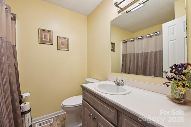 bathroom with vanity, a textured ceiling, and toilet