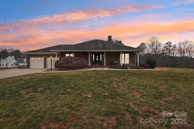 view of front of property with a garage and a lawn