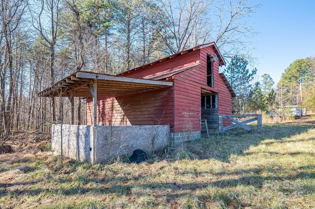 view of side of property with an outbuilding and a lawn