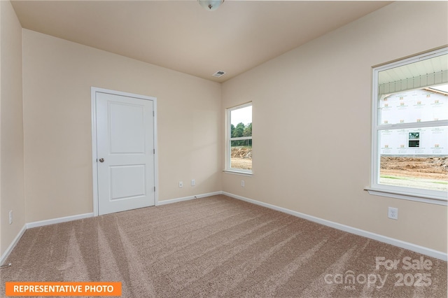 unfurnished room with visible vents, baseboards, and carpet