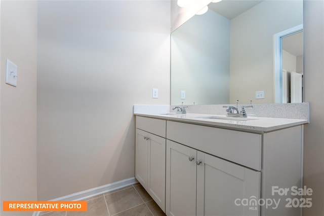 bathroom featuring double vanity, a sink, tile patterned flooring, and baseboards