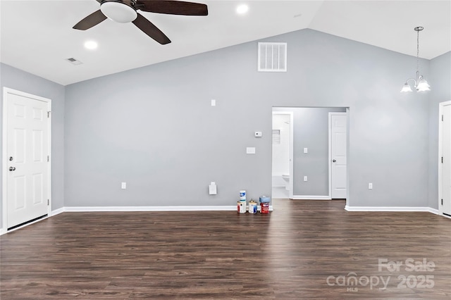 unfurnished living room with dark wood-type flooring, ceiling fan with notable chandelier, and high vaulted ceiling