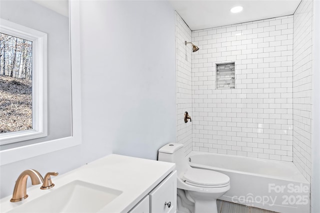 full bathroom with vanity, tiled shower / bath, and toilet