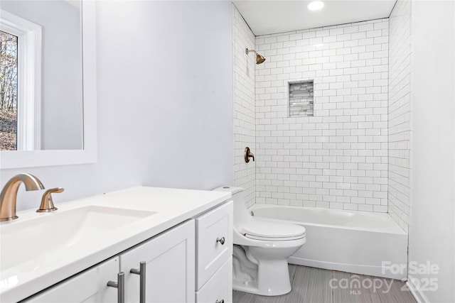 full bathroom with tiled shower / bath combo, vanity, tile patterned flooring, and toilet