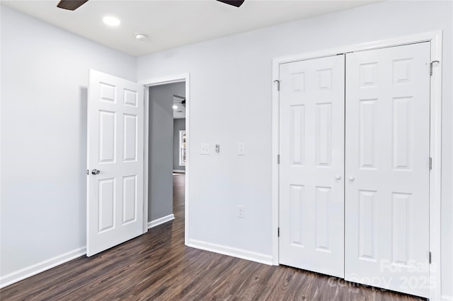 unfurnished bedroom with dark wood-type flooring, a closet, and ceiling fan