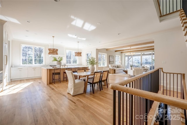 dining space featuring sink, crown molding, and light hardwood / wood-style floors