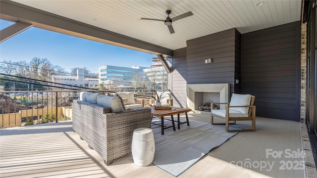 view of patio featuring an outdoor living space with a fireplace and ceiling fan