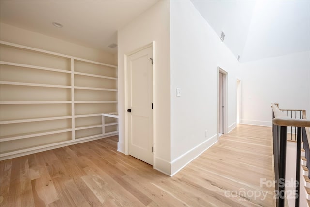 hall featuring lofted ceiling and light hardwood / wood-style floors