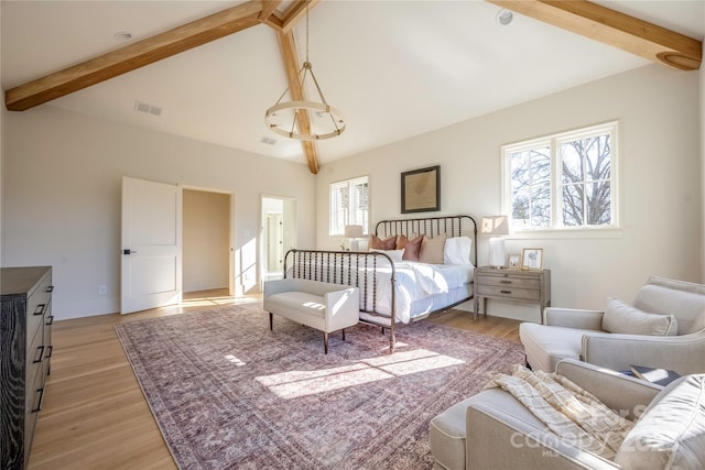 bedroom featuring lofted ceiling with beams and light wood-type flooring