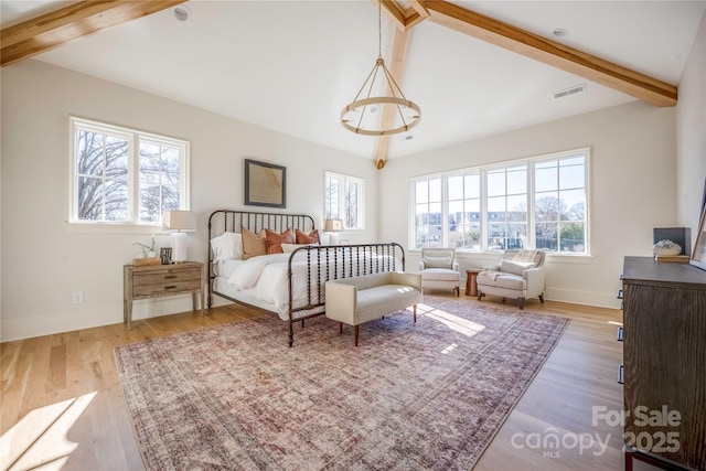 bedroom featuring hardwood / wood-style floors, multiple windows, and vaulted ceiling with beams