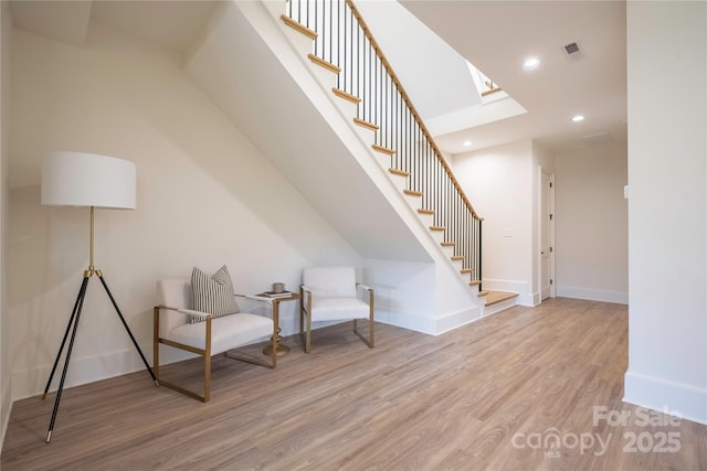 sitting room with a skylight and light hardwood / wood-style flooring