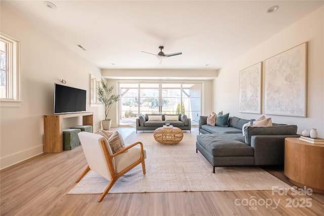 living room featuring ceiling fan and light hardwood / wood-style flooring