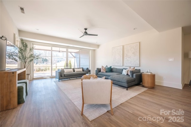 living room with light hardwood / wood-style floors and ceiling fan