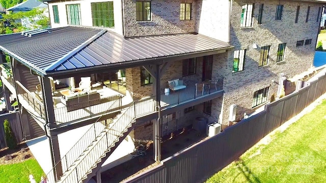 exterior space with stairway, brick siding, a standing seam roof, and metal roof