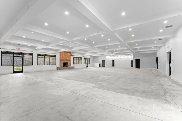 unfurnished living room featuring beamed ceiling, a large fireplace, and coffered ceiling