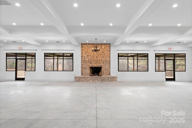 unfurnished living room with beamed ceiling, plenty of natural light, and a fireplace