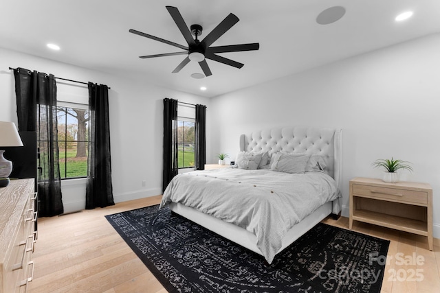 bedroom featuring multiple windows, ceiling fan, and light wood-type flooring