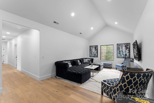 living room with hardwood / wood-style flooring and high vaulted ceiling