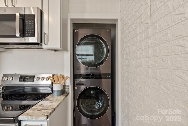 laundry room featuring stacked washer / drying machine