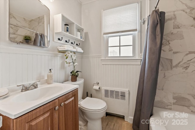 full bathroom featuring shower / bath combo, radiator heating unit, vanity, wood-type flooring, and toilet