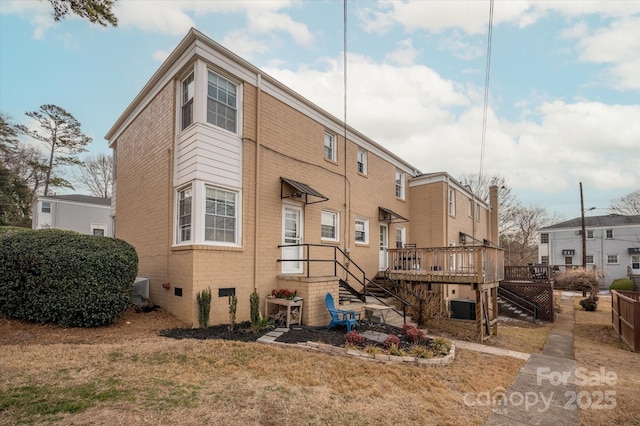 back of property featuring a wooden deck, central AC, and a lawn