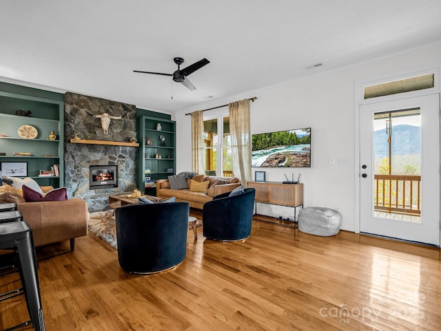 living room with hardwood / wood-style floors, a fireplace, and built in shelves