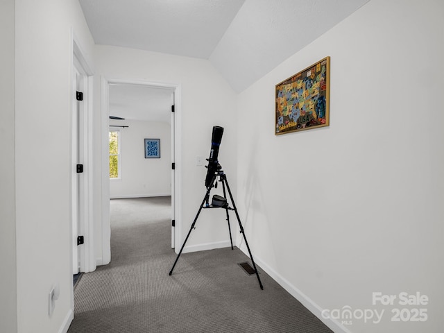 corridor featuring vaulted ceiling and carpet floors