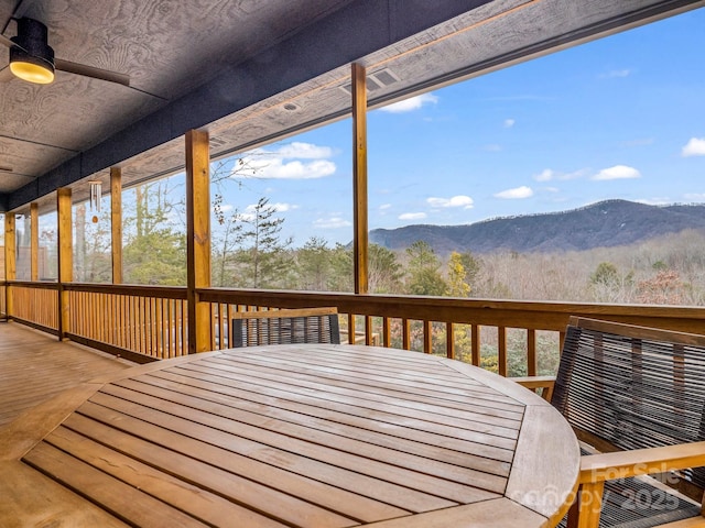 wooden terrace featuring ceiling fan and a mountain view