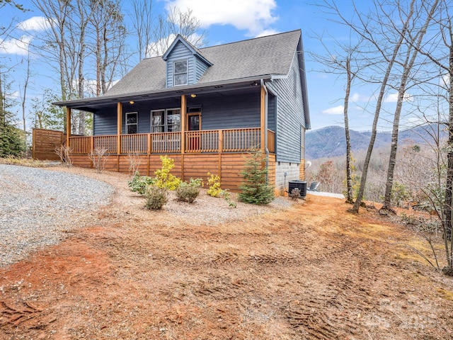 view of front of property featuring a mountain view, covered porch, and central air condition unit