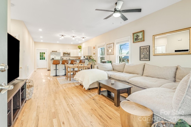 living room with ceiling fan and light wood-type flooring