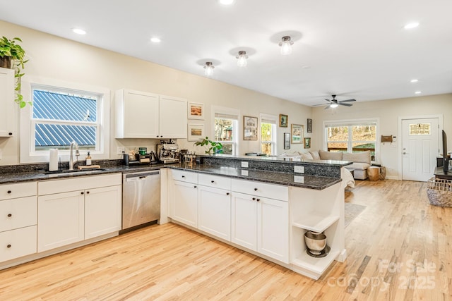 kitchen featuring sink, dark stone countertops, dishwasher, kitchen peninsula, and white cabinets