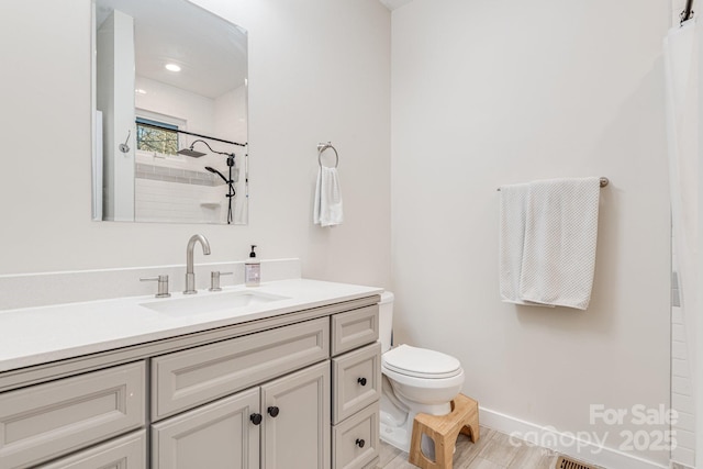 bathroom with vanity, toilet, and a shower