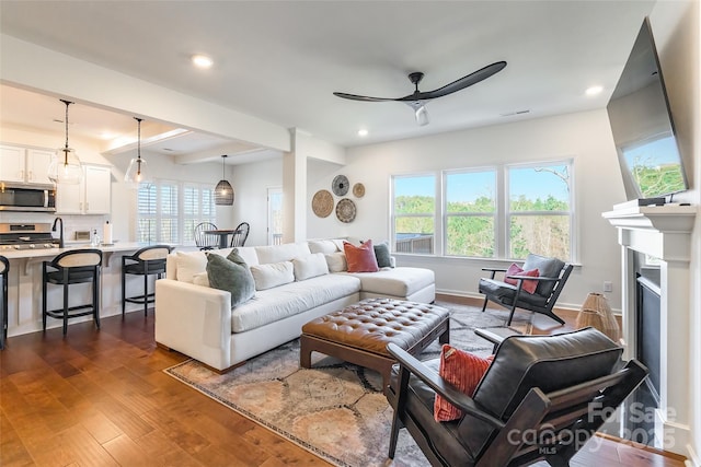 living room featuring dark wood-style floors, a fireplace, recessed lighting, a ceiling fan, and baseboards