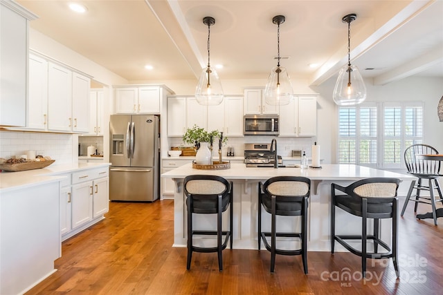 kitchen with appliances with stainless steel finishes, light countertops, and white cabinetry