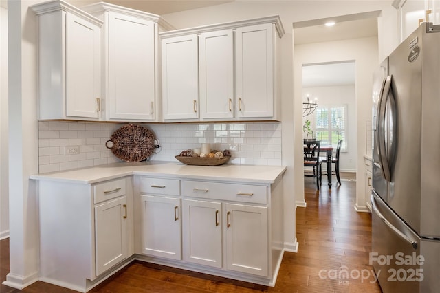 kitchen with light countertops, stainless steel fridge, and white cabinets