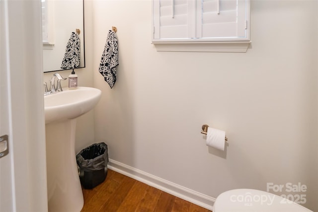 bathroom featuring a sink, wood finished floors, and baseboards