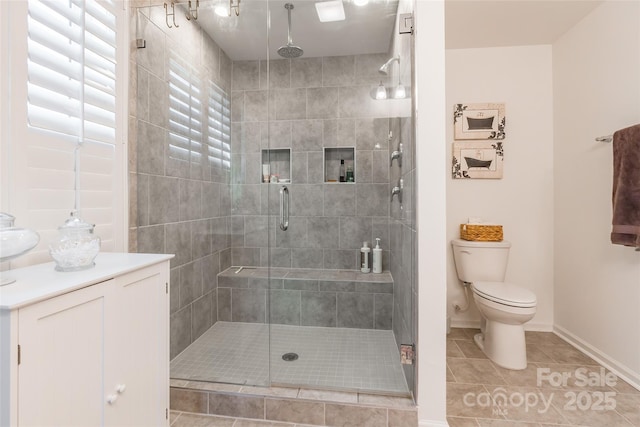 full bathroom featuring baseboards, a shower stall, toilet, and tile patterned floors