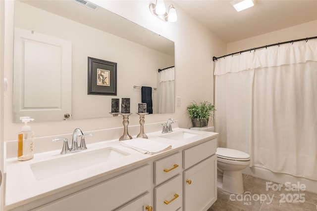 bathroom featuring double vanity, visible vents, a sink, and tile patterned floors