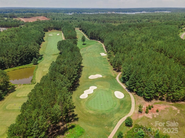 birds eye view of property featuring a water view, a forest view, and view of golf course