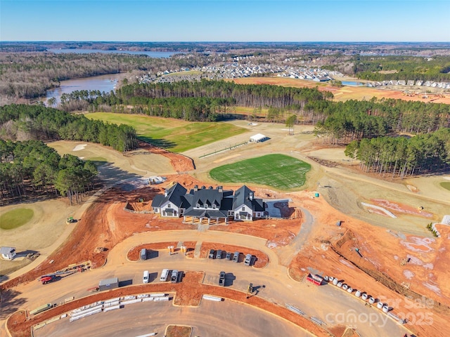 drone / aerial view with golf course view and a water view