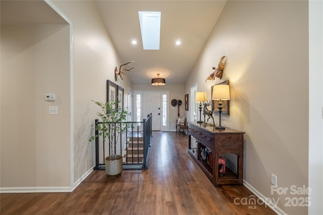 corridor featuring a skylight and dark hardwood / wood-style floors