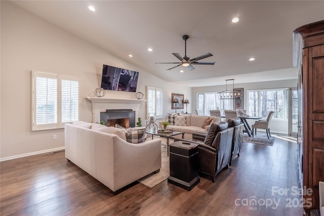 living room with dark wood-type flooring, lofted ceiling, plenty of natural light, and ceiling fan