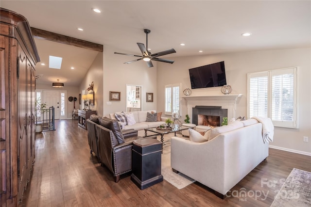 living room featuring ceiling fan, dark hardwood / wood-style flooring, and lofted ceiling with skylight