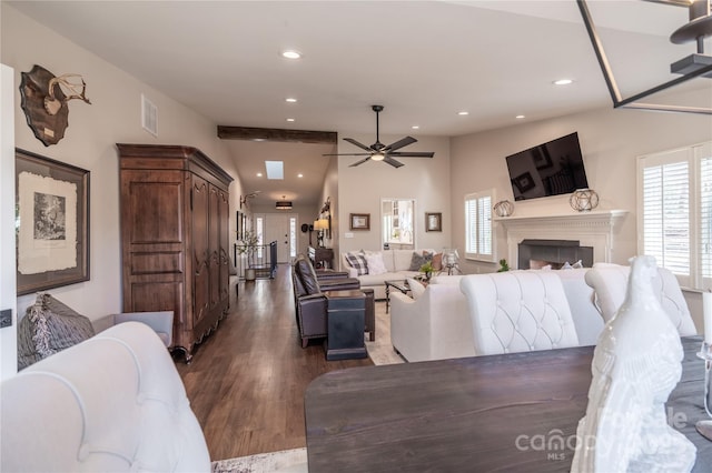 living room featuring ceiling fan, vaulted ceiling with beams, and dark hardwood / wood-style floors