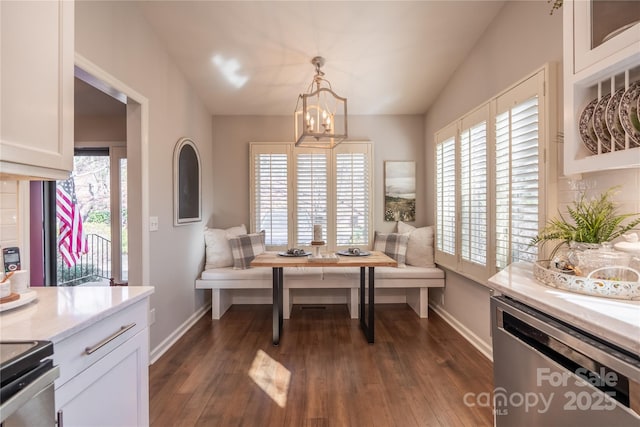 dining space featuring vaulted ceiling, a notable chandelier, dark hardwood / wood-style flooring, and breakfast area