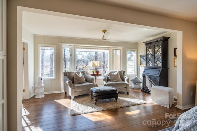 living area with ceiling fan and dark hardwood / wood-style flooring