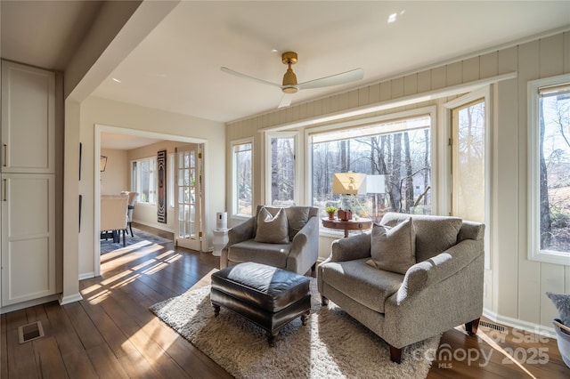 living room with ceiling fan and dark wood-type flooring