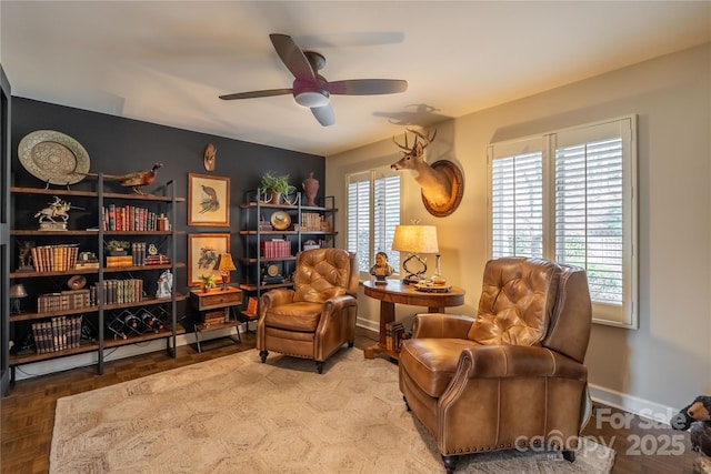 sitting room with ceiling fan and parquet flooring