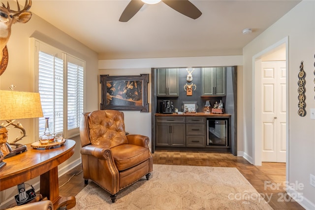 living area featuring ceiling fan, a wealth of natural light, beverage cooler, and parquet floors